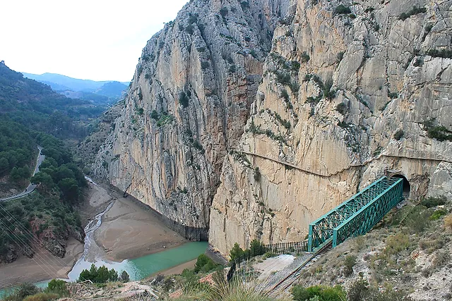 The walkway on the cliff face above the green railway bridge and the reservoir